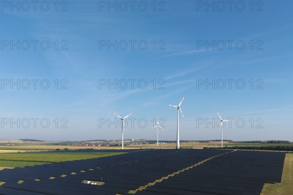 Fields full of solar panels with several wind turbines under a cloudless sky, near Kitzingen, Lower Franconia, Bavaria, Germany
