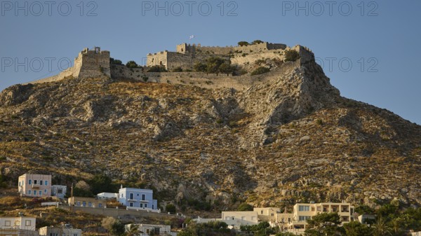 Historic castle on rocky hill under blue sky with coastal houses in the foreground, Pandeli Castle, Castle, Leros Fortress, St John's Fortress, Apitiki Hill, Pandeli Bay, Agia Marina, Leros, Dodecanese, Greek Islands, Greece
