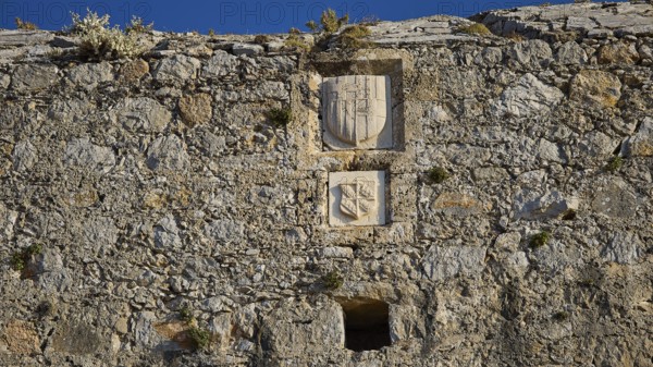 Medieval stone wall with engraved coats of arms and weathered engravings, coat of arms of Emery d'Amboise, Pandeli Castle, Castle, Leros Fortress, St John's Fortress, Apitiki Hill, Pandeli Bay, Agia Marina, Leros, Dodecanese, Greek Islands, Greece