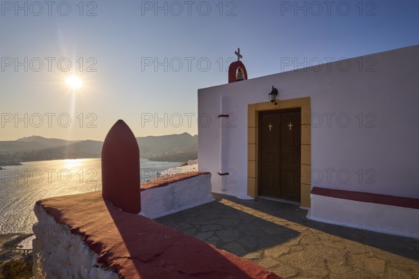 Chapel with cross by the sea at sunset, peaceful atmosphere and classic Greek architecture, red painted world war bomb, Profitis Ilias Church, Prophet Elias Church, evening light, sunset, Ormos Alintas, Agia Marina, Leros, Dodecanese, Greek Islands, Greece