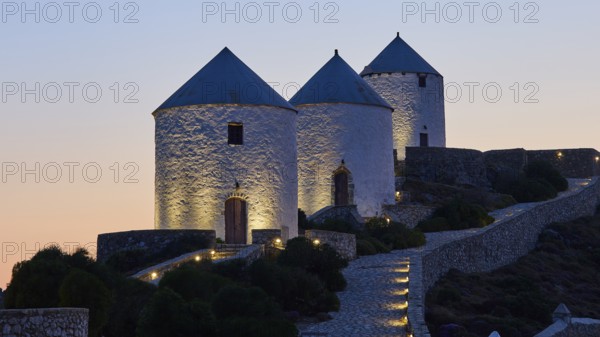 Illuminated windmills in the twilight on a stony hill, Pandeli Castle, castle, Leros fortress, St John's fortress, Apitiki hill, Pandeli bay, windmills, Leros, Dodecanese, Greek Islands, Greece