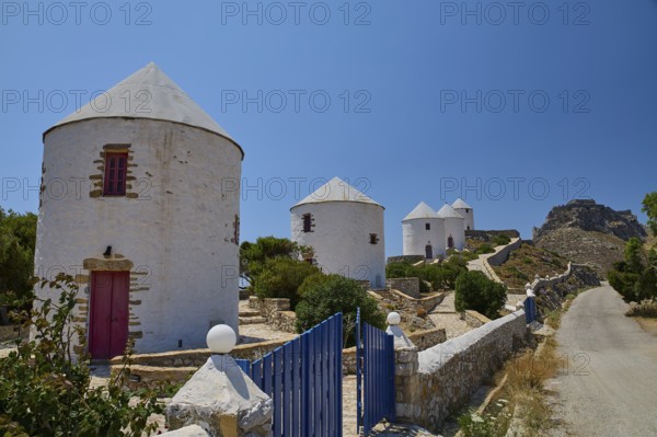 White windmills with red doors along a path under a clear sky on an island, Pandeli Castle, Castle, Leros Fortress, St John's Fortress, Apitiki Hill, Pandeli Bay, Windmills, Leros, Dodecanese, Greek Islands, Greece
