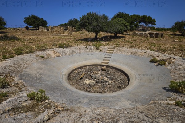Concrete crater in an arid landscape with scattered trees under a blue sky, Lost Place, Air Defence Position, Aerophone, Parabolic Acoustic Mirror, Patella Mountain, WW2, west of Lakki, Leros, Dodecanese, Greek Islands, Greece