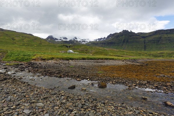 Rocky volcanic landscape near Grundarfjördur, snow-capped mountains on the horizon, Snæfellsnes peninsula, Snaefellsnes, West Iceland, Vesturland, Iceland