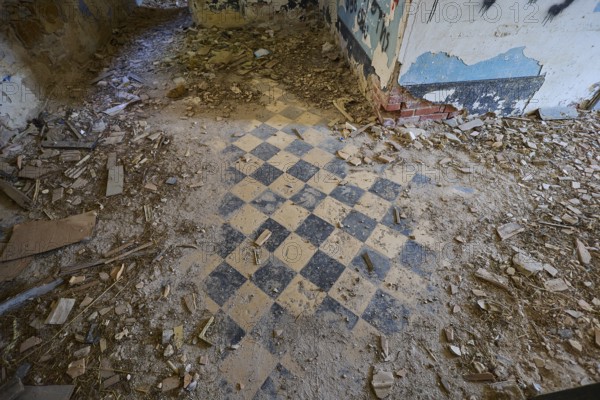 Lost Place, chequered pattern on the floor of a dilapidated room, surrounded by rubble and blue walls, Radio Station, WW2, Agios Nikolaos Radio, Agia Marina, Leros, Dodecanese, Greek Islands, Greece