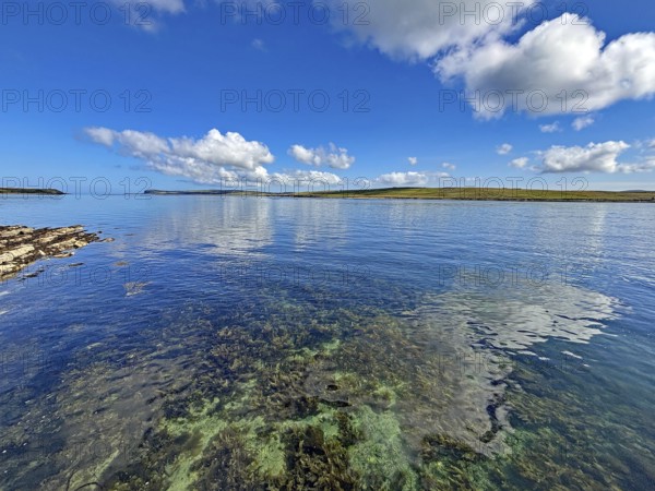 Clear sea with calm atmosphere, blue sky and clouds along the coastline, Hoy, Orkney Islands, Scotland, United Kingdom