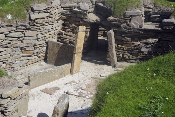Entrance to ancient ruins with stone walls surrounded by grass and moss, Skara Brae, Neolithic settlement, Mainland, Orkney Islands, Scotland, Great Britain