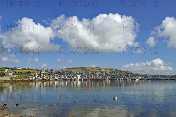 Coastal town with reflecting water, white sky and many clouds, Stromness, Mainland, Orkney Islands, Scotland, United Kingdom