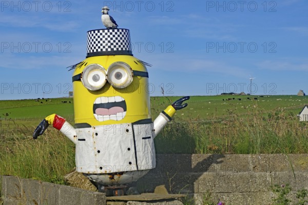 Sculpture of a cartoon figure with a bird on its head, surrounded by a green landscape and blue sky, advertising a snack bar, Orkney Islands, Scotland, Great Britain