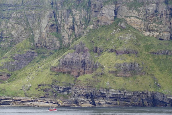 Steep green cliffs with red boat in calm sea, Hoy, Orkney Islands, Scotland, Great Britain