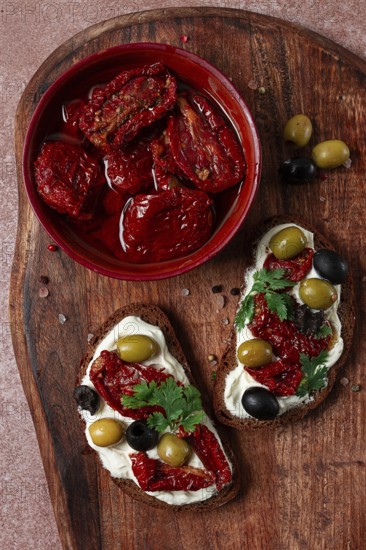 Sandwich with cream cheese, dried tomatoes, olives, breakfast, top view