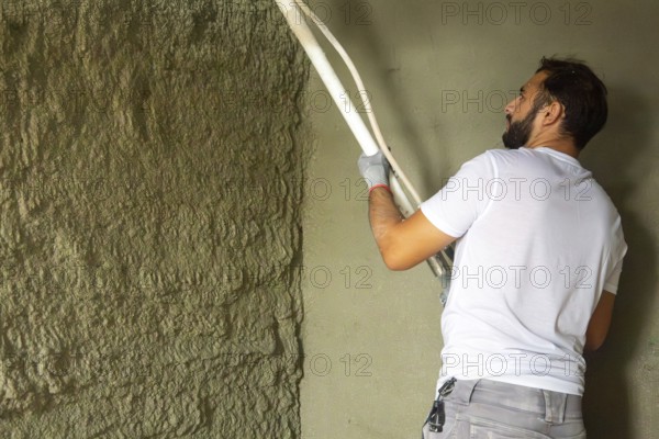 Plasterer applies plaster to the wall