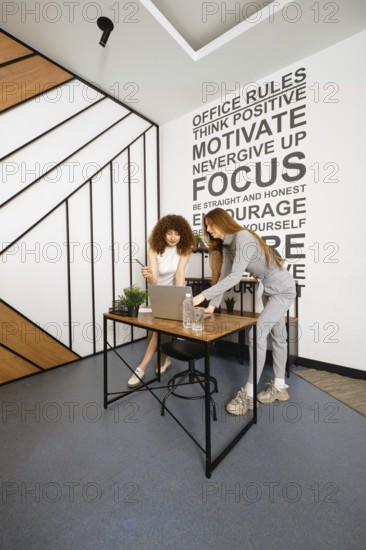 Two women work together in a stylish office dedicated to women's health, discussing plans and strategies
