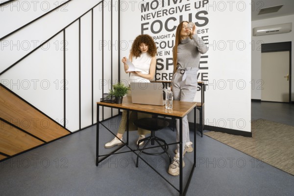 Women watch the download dynamics of their new health monitoring app on their laptop online