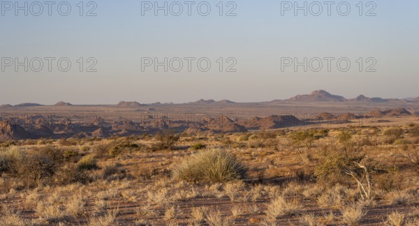 Desert landscape in the evening light at sunset, barren landscape with hills of stacked rocks, Erongo, Damaraland, Namibia