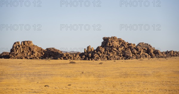 Barren landscape with hills of stacked rocks, desert landscape in the evening light at sunset, Erongo, Damaraland, Namibia