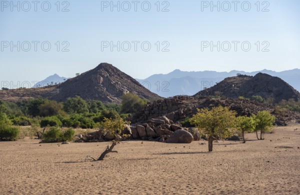 Dry riverbed of the Ugab River, barren landscape with hills of stacked rocks, desert landscape, Erongo, Damaraland, Namibia