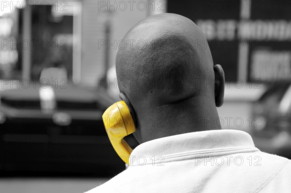 Coloured New Yorker on the phone with yellow handset, New York City, USA