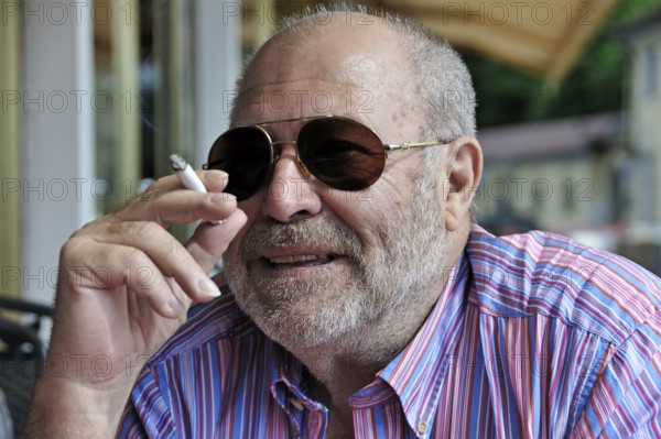 Portrait of an elderly gentleman with a beard, sunglasses and a cigarette in his hand, Tegernsee, Upper Bavaria, Germany