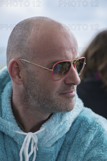 Portrait of a young man with sunglasses and fluffy jacket, Baden-Württemberg, Germany