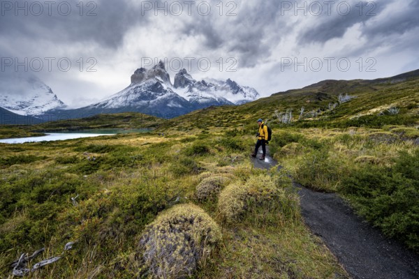 Hikers on the way to the Mirador de los Cuernos, Cuernos del Paine mountain range, dramatic sky, Torres del Paine National Park, Chile