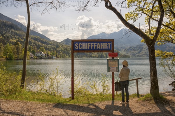 Lake Kochel, tourist reads the navigation map, Kochel, Upper Bavaria, Bavaria