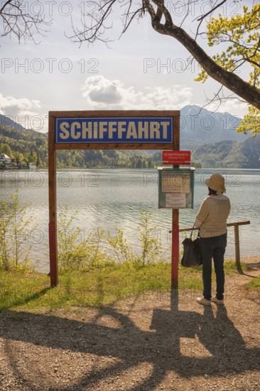 Lake Kochel, tourist reads the navigation map, Kochel, Upper Bavaria, Bavaria