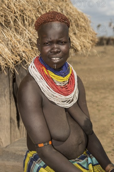 Woman of the Nyangatom ethnic group, also called Bume, with colourful bead necklaces and the typical copper-coloured hair style, Southern Omo Valley, Ethiopia