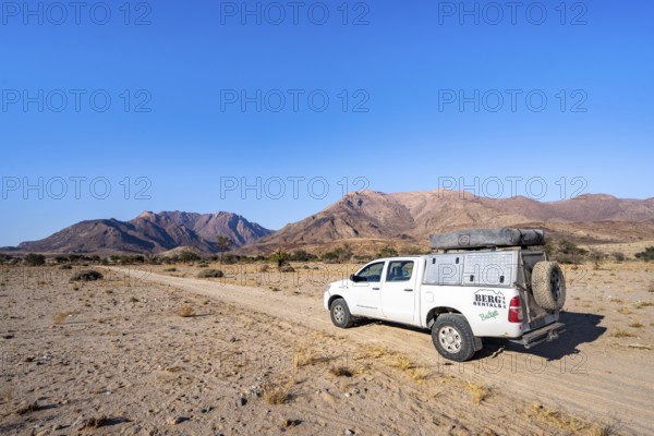 Off-road vehicle on a sandy track, desert landscape with Brandberg, Erongo, Damaraland, Namibia
