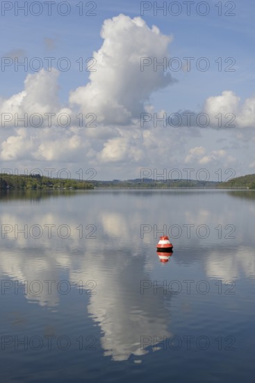 View over the Möhnesee, red and white buoy, blue cloudy sky, reflection on the water surface, Möhnetalsperre, North Rhine-Westphalia, Germany