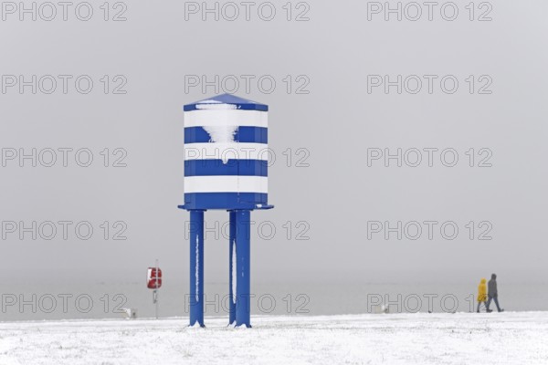 Winter day, onset of winter, snow on the North Sea coast, people walking on the beach promenade of Norddeich, Lower Saxony, Germany