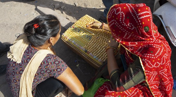 Indian woman bent over jewellery, Sandar Market Girdikot, old town of Jodhpur, Rajasthan, India