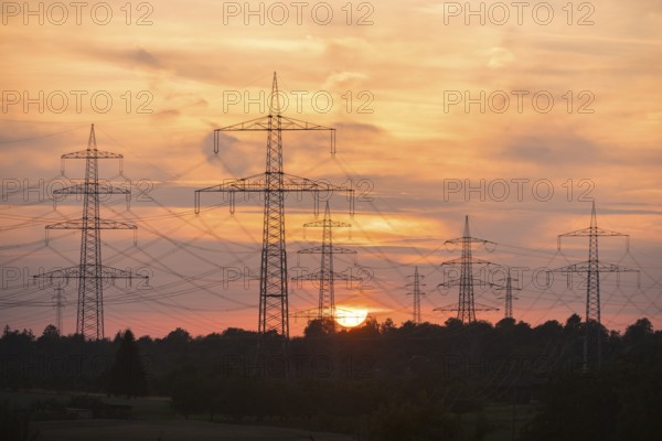 Power lines towering into the evening sky during a sunset, Waiblingen, Baden-Württemberg, Germany