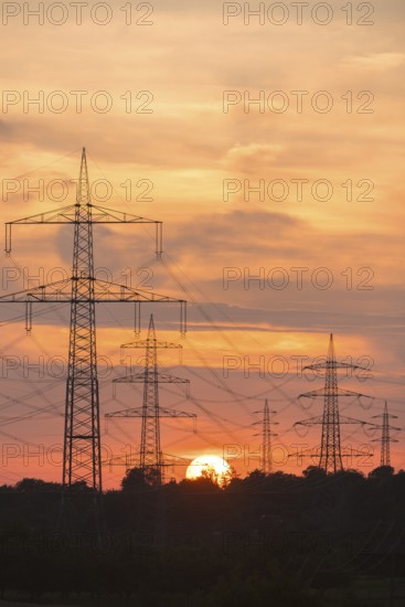 High-voltage power lines at sunset with intense orange sky, Waiblingen, Baden-Württemberg, Germany