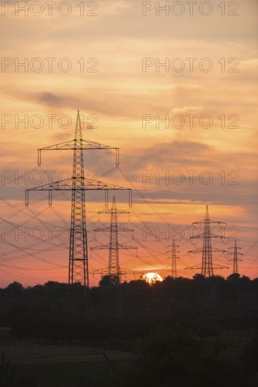 Dramatic silhouettes of electricity pylons against a colourful sky, Waiblingen, Baden-Württemberg, Germany