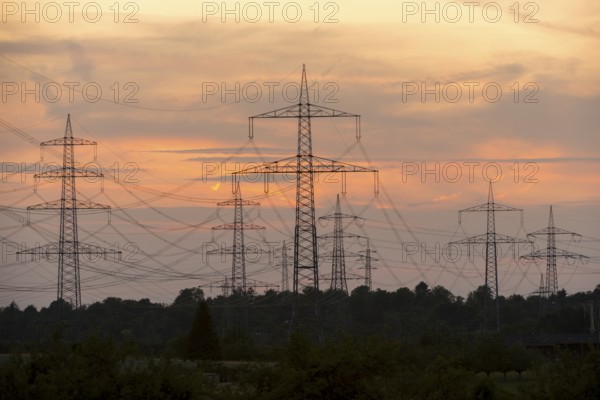 Electricity pylons in front of a pastel-coloured sunset sky with clouds, Waiblingen, Baden-Württemberg, Germany
