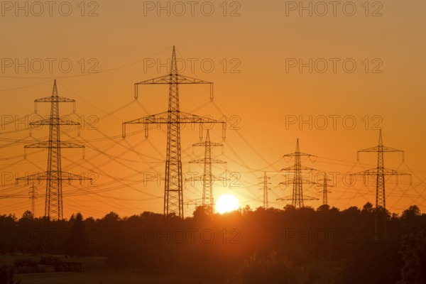 Electricity pylons in front of a glowing sunset on the horizon, Waiblingen, Baden-Württemberg, Germany