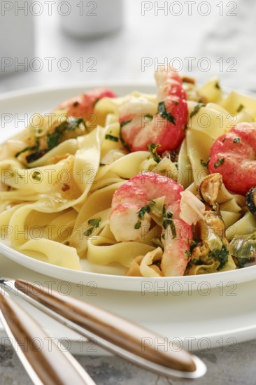 A delicious plate of fettuccine allo scoglio features perfectly cooked pasta topped with shrimp and mussels, garnished with fresh herbs. Enjoying this seafood dish can elevate any dining experience