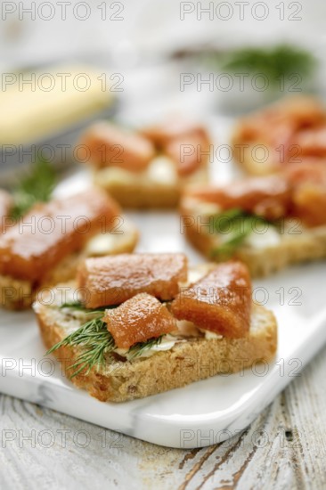 Close-up view of exquisite open-faced sandwiches with herring caviar on a slice of bread, garnished with dill