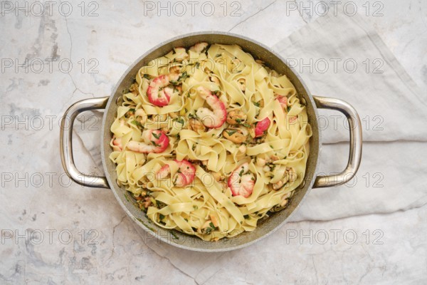 Delicious fettuccine allo Scoglio presented in a rustic bowl, showcasing succulent seafood and fresh herbs. Perfectly cooked pasta is complemented by the vibrant flavors of shrimp and other seafood