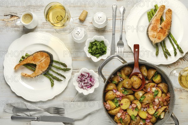 Two plates of grilled salmon served on asparagus sit alongside a pot of herbed potatoes. Fresh cilantro and diced onions are shown, enhancing the vibrant colors of the dishes presented