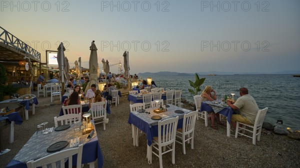 Restaurant at the Turkish ferry harbour, dinner by the water at sunset with white-blue tables and a cosy atmosphere, Kos Town, Kos, Dodecanese, Greek Islands, Greece