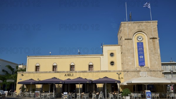 Cinema, Eleftherias Square, Historic building with clock tower and cafés under a blue sky, Kos Town, Kos, Dodecanese, Greek Islands, Greece