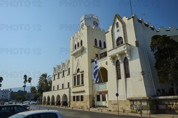 Palace of Justice, Colonial building, A street with a historic building, clock tower and palm trees under a bright blue sky, Kos Town, Kos, Dodecanese, Greek Islands, Greece