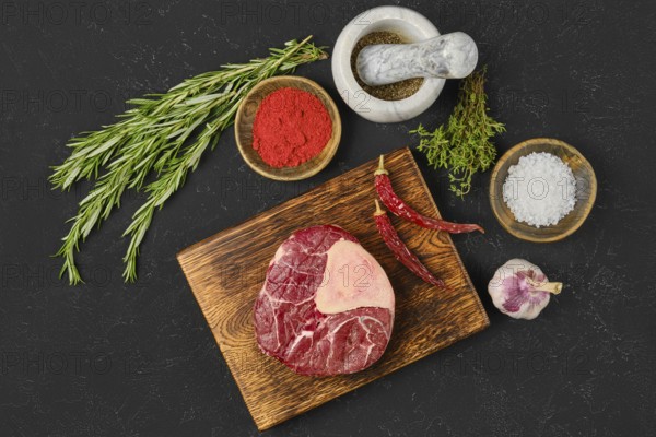 A fresh beef cut rests on a wooden board, surrounded by fresh herbs, spices, and a mortar. The kitchen setting highlights the preparation for a flavorful dish being planned