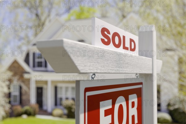 Sold for sale real estate sign in front of beautiful house