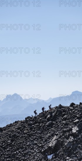Hikers against the light on a ridge, Stubai Alps, South Tyrol, Italy
