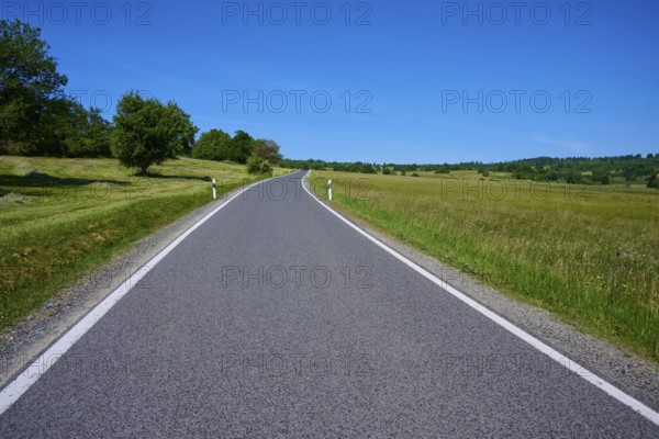 Rural road leads through green meadows under a clear blue sky, summer, Franzosenweg, Lange Rhön, Oberelsbach, Rhön, Bavaria, Germany