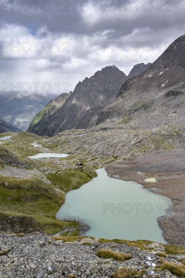 View of the turquoise-blue mountain lake Großer Gradensee, with the peaks of Petzeck and Kruckelkopf behind, Schober Group, Hohe Tauern National Park, Carinthia, Austria