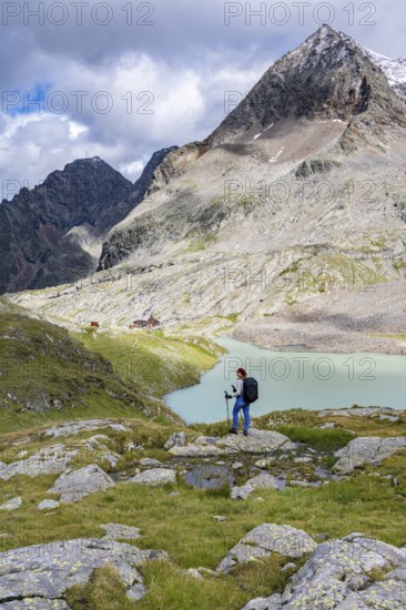 Hiker on the way to the Adolf Nossberger Hut, view of the turquoise-blue mountain lake Großer Gradensee, Schober Group, Hohe Tauern National Park, Carinthia, Austria